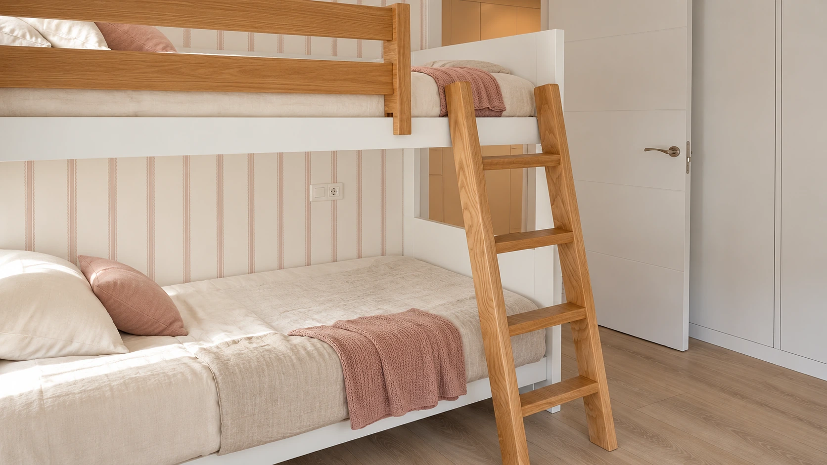 Detalle del dormitorio juvenil de Chipiona con camas hechas, escalera de madera y almacenaje