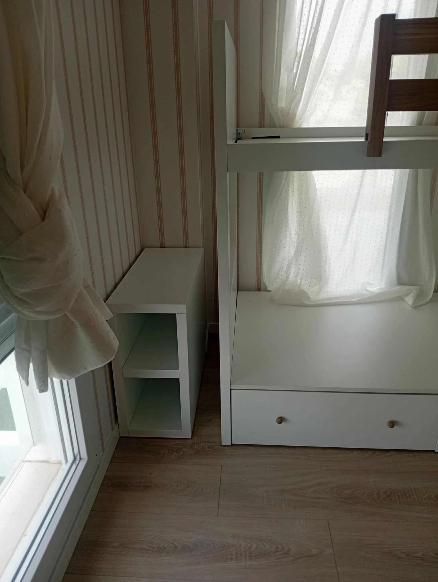 Fotografía original del cajón bajo la cama y la pequeña librería junto a la ventana