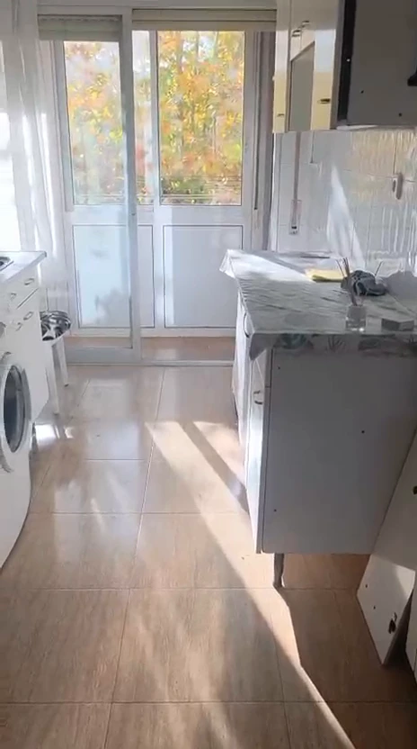 Estado inicial de la cocina antes de la reforma, con muebles blancos y acabados antiguos