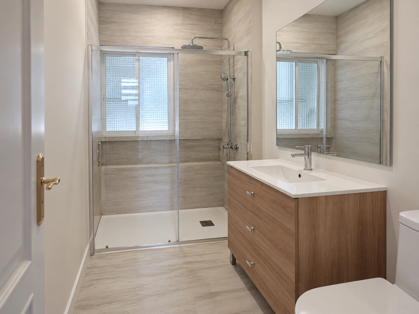 Baño reformado para alquiler, con ducha y mueble de madera